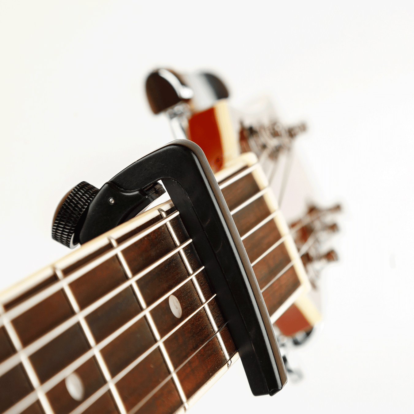Black capo on guitar neck